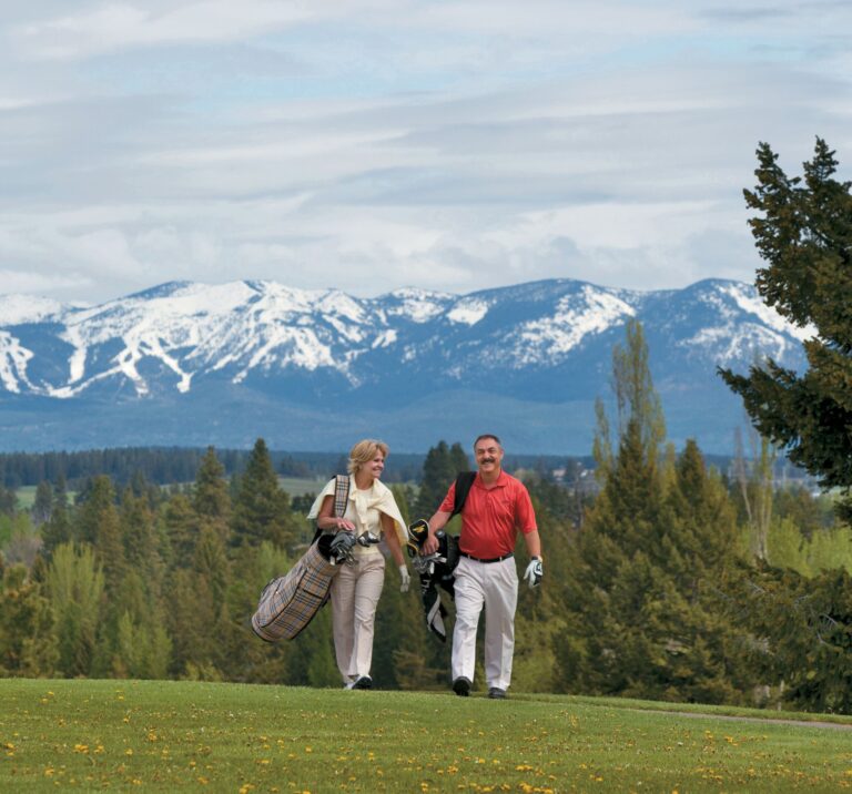 Couple on the golf course with Big Mountain in the background