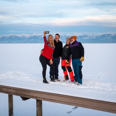 Friends standing on dock at Flathead Lake Montana in winter