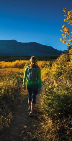 Single hiker on trail amid fall foliage in the valley