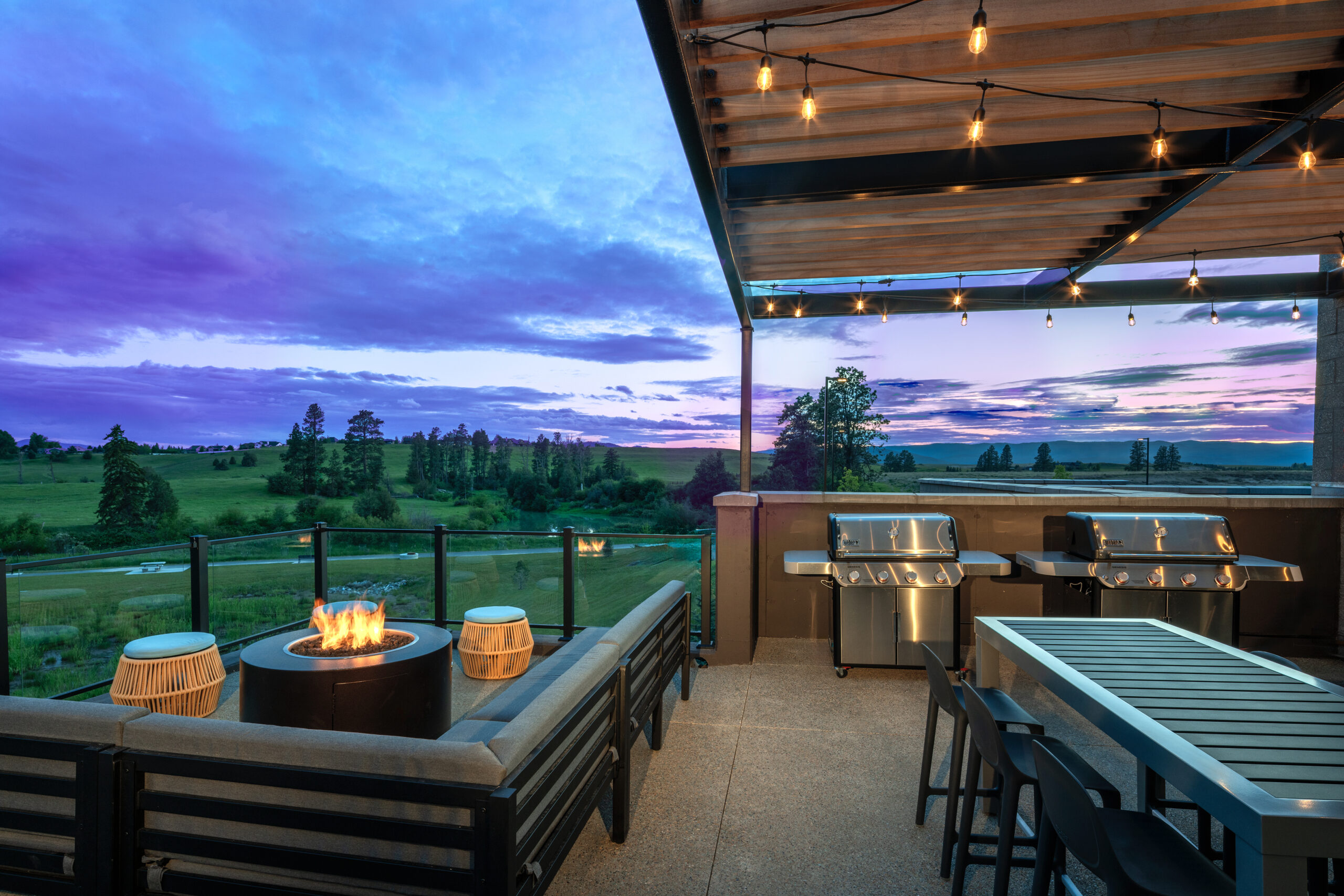 Hotel outdoor living area with grill, seating, and fire pit