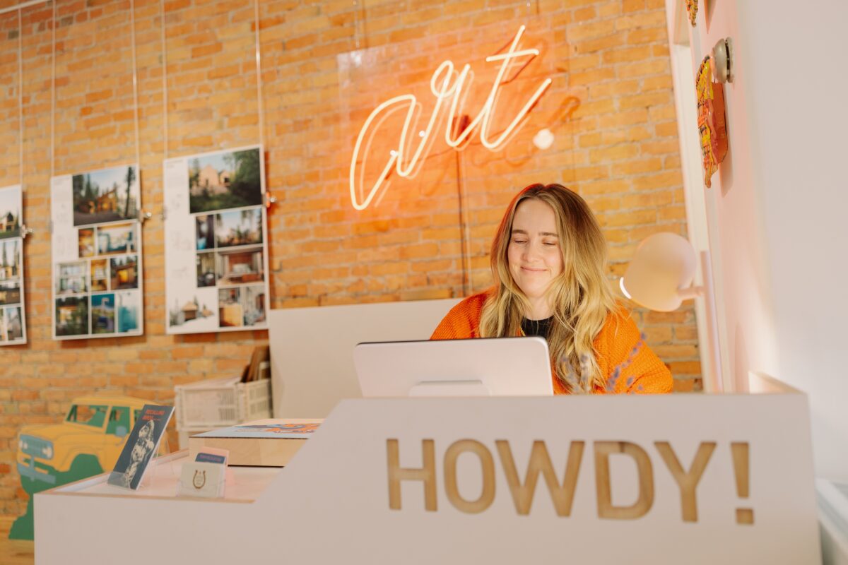 Person sitting at a desk in a sunny art gallery
